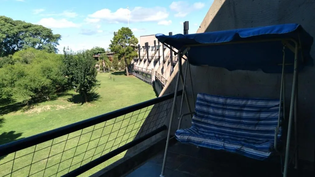 Hamaca de dos plazas en un balcón con vista al jardín